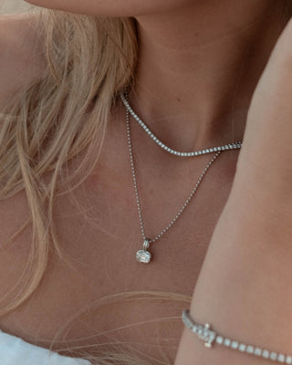 Two diamond charms set in 14k yellow gold on a gold chain. 